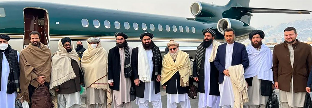Photo of Taliban leaders standing on the tarmac next to an airplane before heading to Oslo for international talks